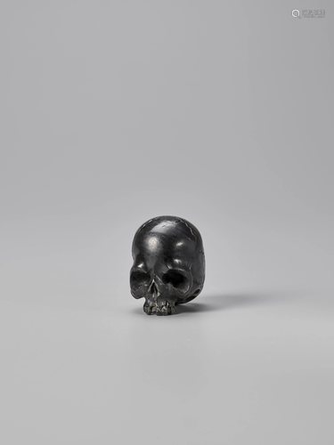 AN EBONY WOOD NETSUKE OF A SKULL