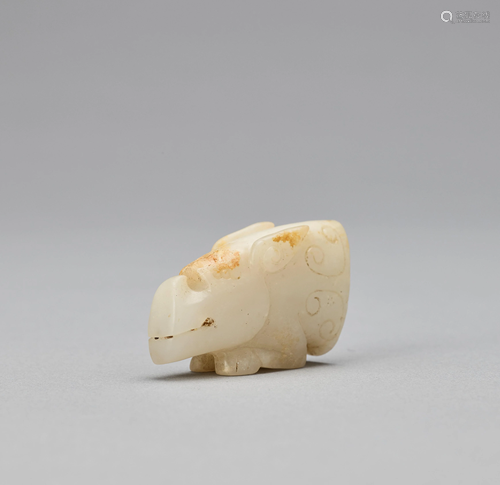 AN ARCHAISTIC WHITE JADE MYTHICAL BEAST HEAD,…