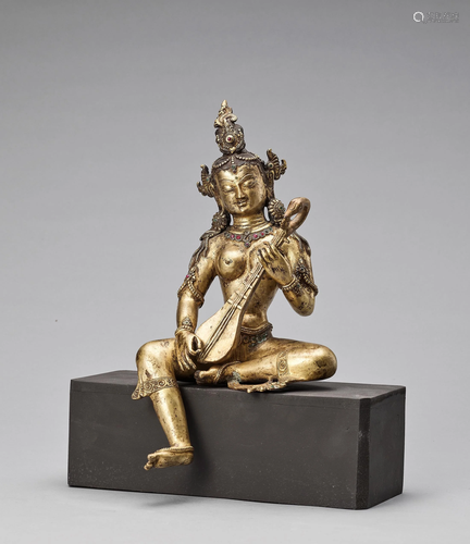 A RUBY-INLAID GILT BRONZE FIGURE OF SARASVATI