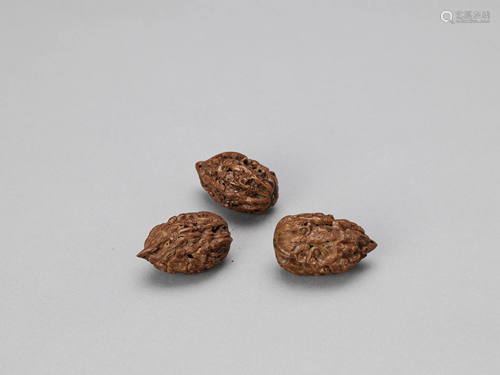 THREE CARVED '100 LUOHANS' NUTS, LATE QING