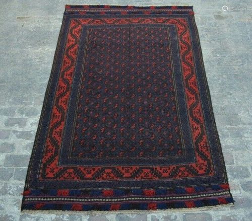 A VINTAGE AFGHANI WOVEN AREA RUG.