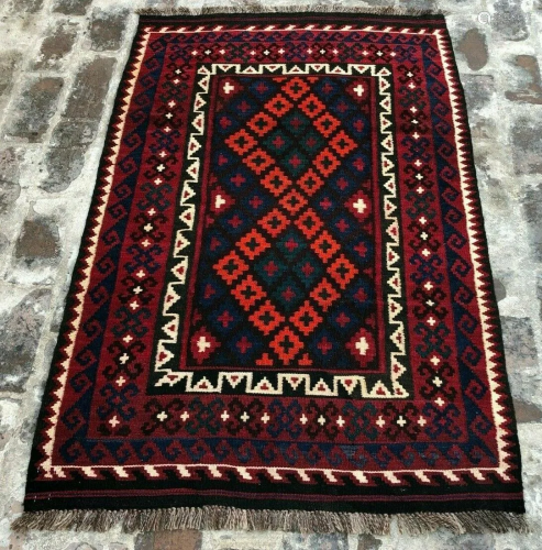 A VINTAGE AFGHANI WOVEN AREA RUG.