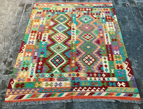 A VINTAGE AFGHANI WOVEN SHIRAZI AREA RUG.