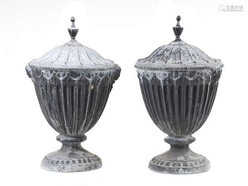 A pair of cast lead garden urns in George III Adam taste