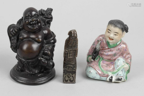 A small oriental pottery figure modelled as a seated