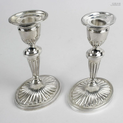 A pair of modern silver candlesticks, each with filled