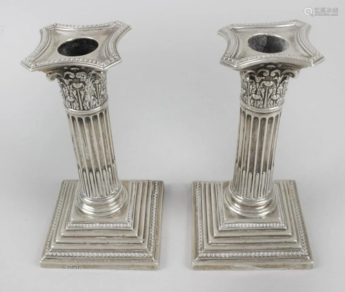 A pair of late Victorian silver mounted candlesticks,