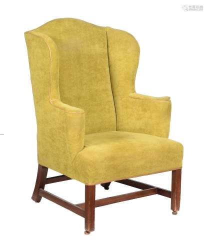 A mahogany and green upholstered wing armchair in George III style