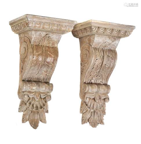 A pair of limed carved oak wall brackets