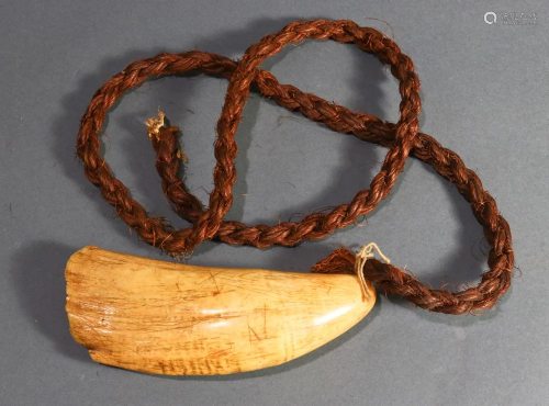A Tambua whale tooth with necklace of woven fiber