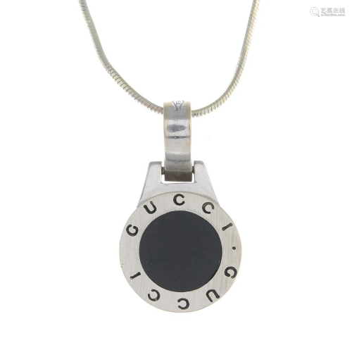 An onyx circular pendant, with chain. Each st…
