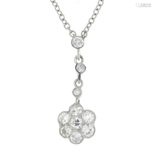 A diamond floral pendant, suspended from an …