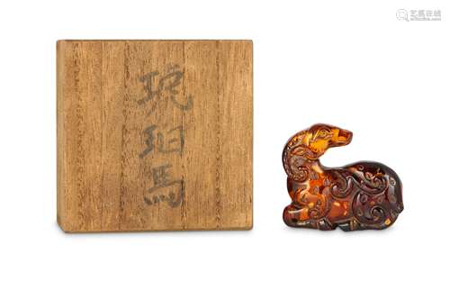 A CHINESE GILT-SPLASH AMBER CARVING OF A RAM.