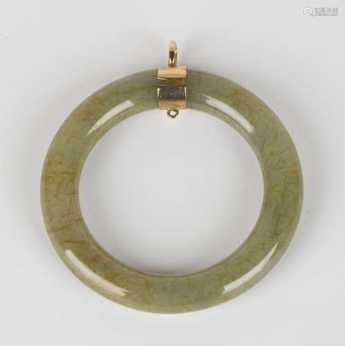 A gold mounted celadon jade pendant of open circular form, diameter 5.3cm.Buyer’s Premium 29.4% (