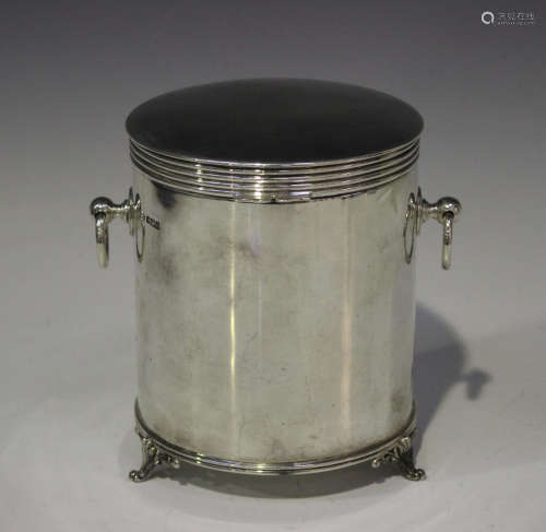 An Edwardian silver cylindrical biscuit barrel, the hinged lid with reeded rim, flanked by ring