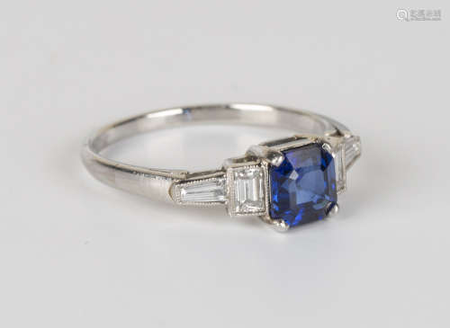 A platinum, sapphire and diamond ring, claw set with an asscher cut sapphire between baguette cut