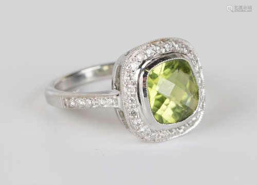 An 18ct white gold, peridot and diamond ring, the cushion cut peridot within an openwork surround of
