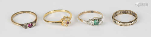 A gold, platinum, green and colourless synthetic gem set three stone ring in a crossover design,