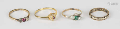 A gold, platinum, green and colourless synthetic gem set three stone ring in a crossover design,