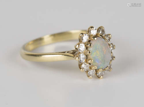 An 18ct gold, opal and diamond oval cluster ring, claw set with the oval opal within a surround of