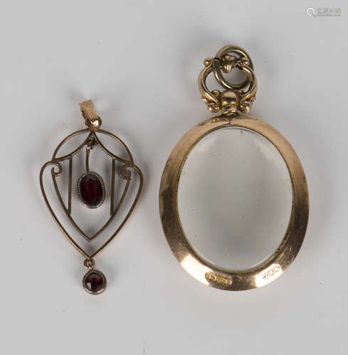 An Edwardian 9ct gold mounted oval glazed pendant locket, Birmingham 1909, length 4cm, and a gold