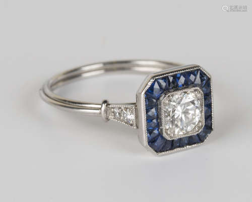A platinum, diamond and sapphire ring, mounted with a circular cut diamond within a canted corner