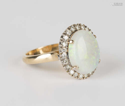 A gold, opal and diamond ring, claw set with an oval opal within a surround of circular cut