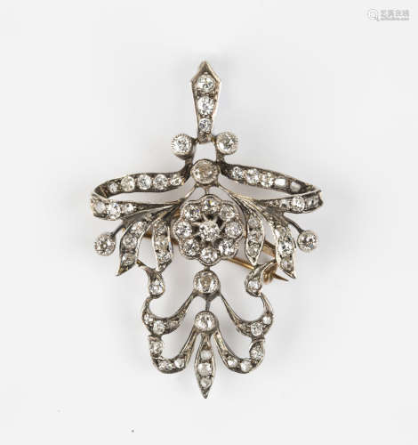 A Victorian gold and diamond pendant brooch in a floral and scroll design, mounted with circular and
