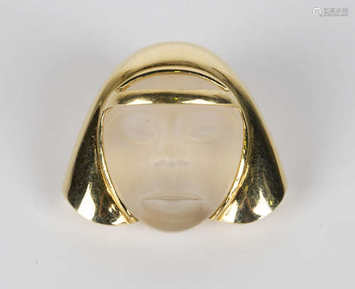 An 18ct gold and rock crystal pendant, carved as a mask framed by stylized hair and headband, with a