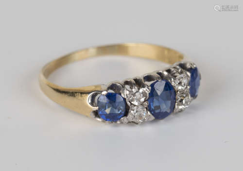 An Edwardian 18ct gold, sapphire and diamond ring, claw set with an oval cut sapphire and two