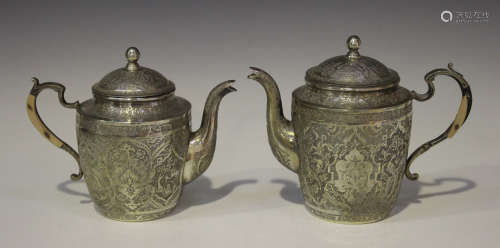 Two 20th century Persian white metal graduated coffee pots, each typically engraved with panels of