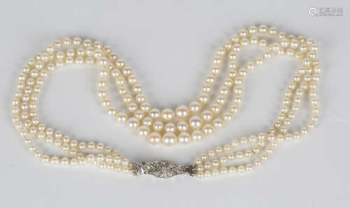 A three row necklace of graduated cultured pearls on a diamond set shaped oval clasp, length of