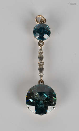 A blue zircon two stone pendant, mid-20th century, claw set with the principal circular cut blue