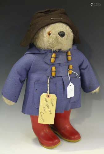 A Gabrielle Designs Paddington Bear with amber and black eyes, wearing a brown hat, blue duffel coat