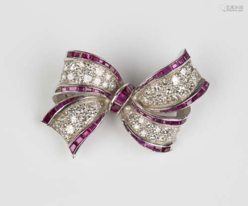 A ruby and diamond brooch, designed as a ribbon tied bow, set with calibre cut rubies and circular