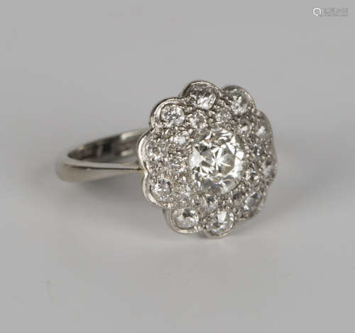 A white gold, platinum and diamond cluster ring, mounted with the principal cushion cut diamond