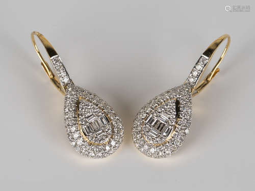 A pair of gold, baguette and circular cut diamond earrings, each in a pear shaped design, with