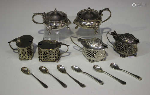 A matched pair of silver circular mustards, each raised on lion mask shouldered scroll legs