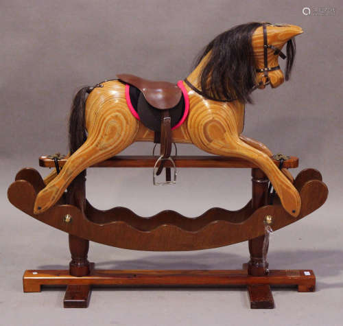 A modern carved wood rocking horse by Ian Armstrong, with amber and black eyes, mane, tail and