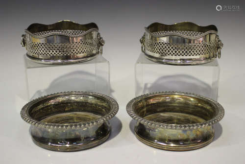 A pair of Elizabeth II silver wine coasters with wavy gadrooned rims and pierced sides, flanked by