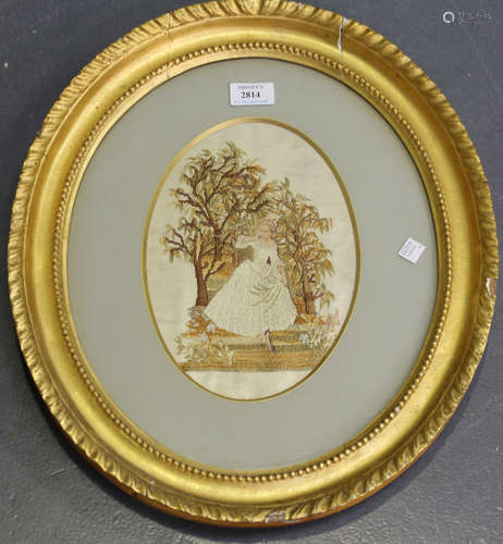 A late 19th century oval silkwork panel, worked with a lady in a woodland, 25cm x 17.5cm, within a