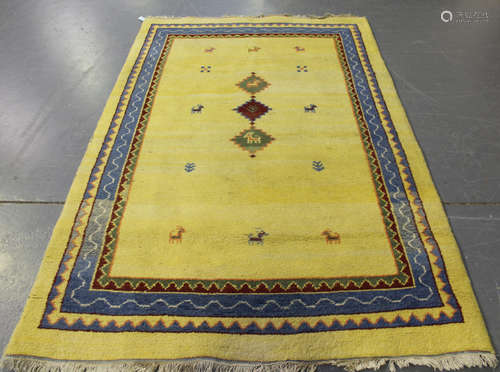 A Persian gabbeh rug, late 20th century, the yellow field sparsely decorated with three stepped