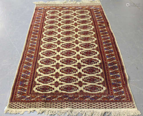 A Pakistan bokhara rug, mid/late 20th century, the ivory field with three columns of guls, within