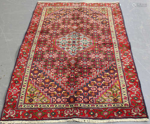 A North-west Persian rug, mid/late 20th century, the red field with a pale blue medallion, supported