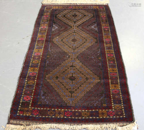 A Beluche rug, Afghan/Persian borders, mid/late 20th century, the aubergine field with three