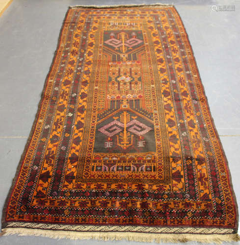 An Afghan Beluche kelleh, mid-20th century, the charcoal field with a column of angular motifs,