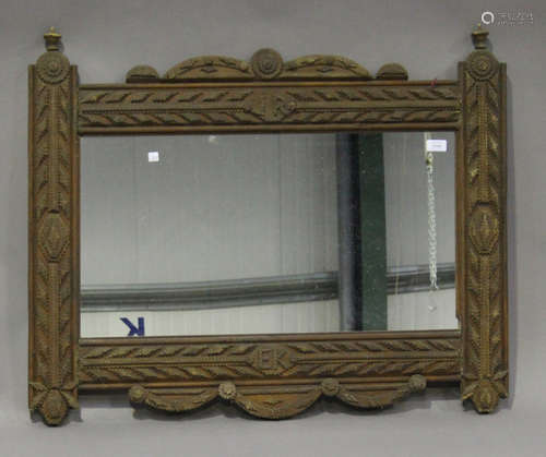 A late 19th/early 20th century tramp art wall mirror, the frame with overall geometric chip carved