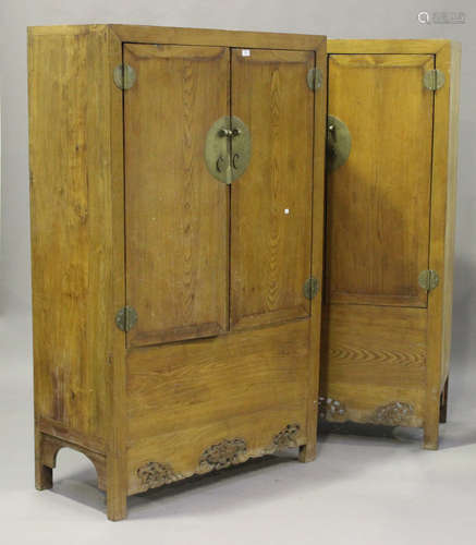 A pair of 20th century Chinese softwood side cabinets, each fitted with a pair of panel doors,