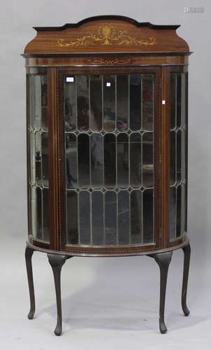 An Edwardian mahogany bowfront display cabinet with inlaid decoration, fitted with a leaded glass