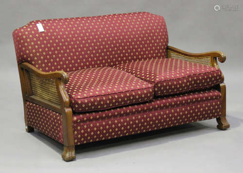 A George V walnut framed three-piece bergère suite, upholstered in claret patterned fabric, on